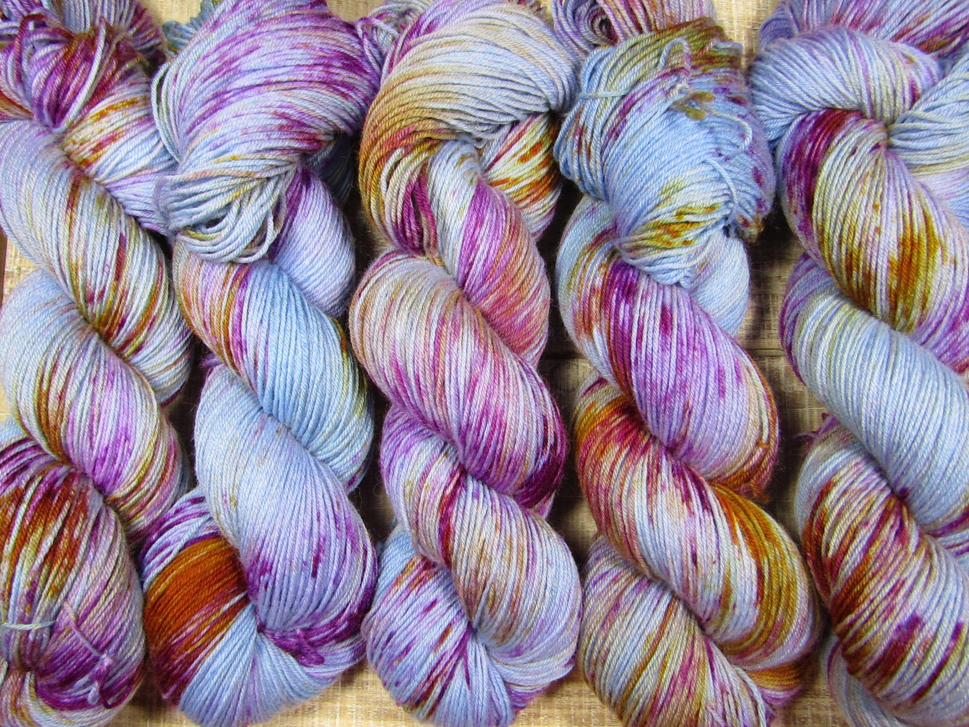 Hand-Dyed Yarn BillieJean is blue yarn with areas of monarch orange and berry crush.