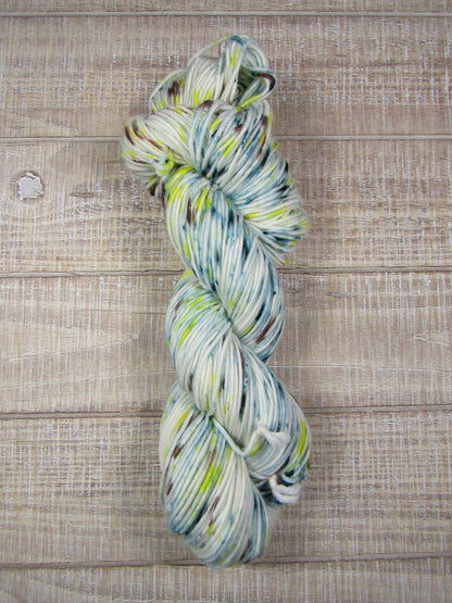 Hand-dyed yarn - Miles Merino/Cashstyle nylon worsted weight yarn with blue/green, yellow, and brown speckles.