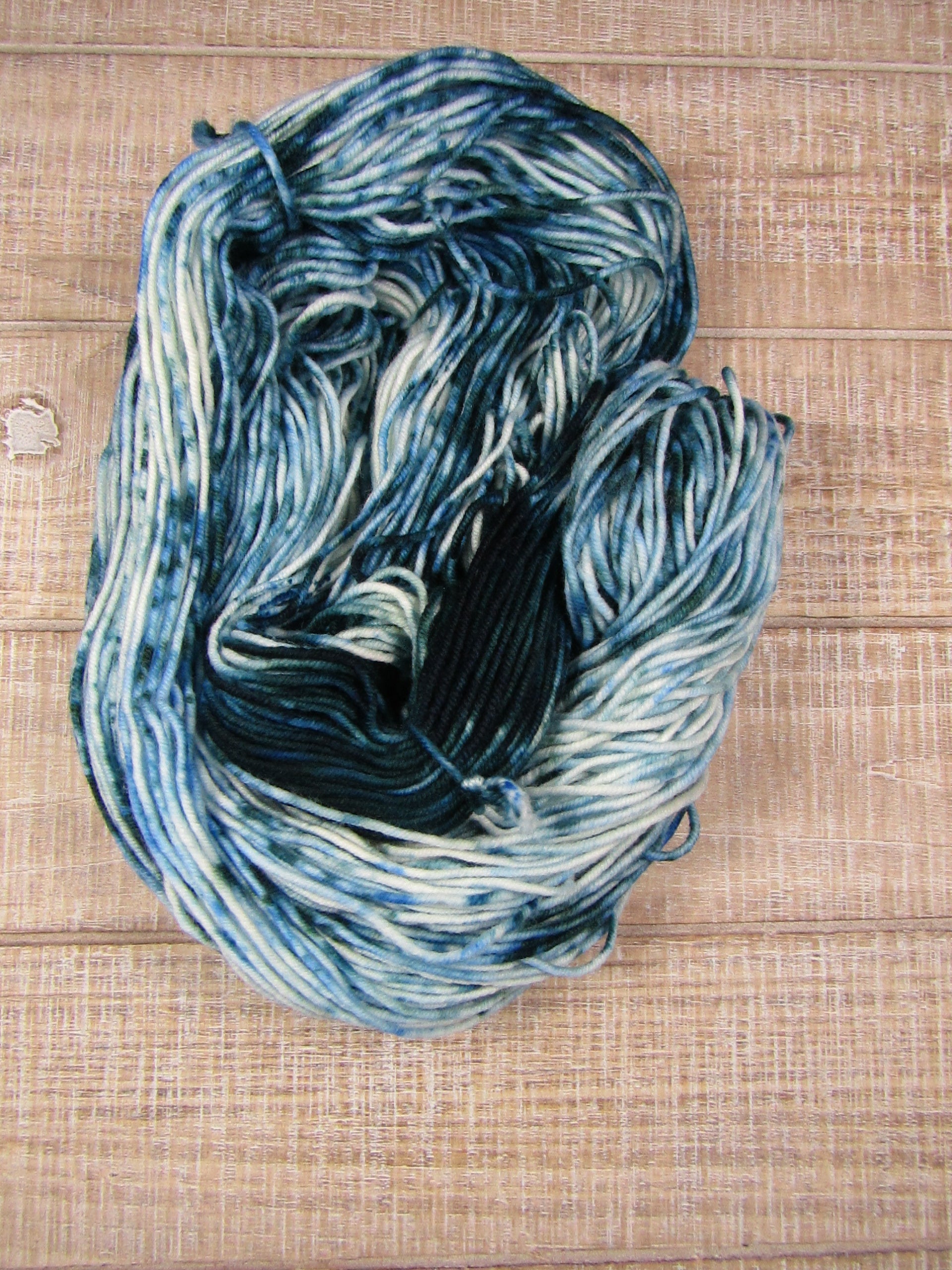 Hand-dyed yarn with an area of blue/green and blue/green speckles worsted weight 