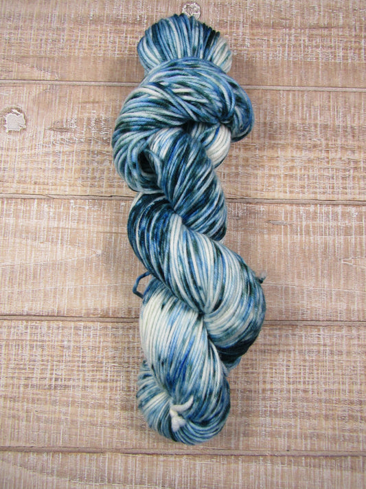 Hand-dyed yarn with an area of blue/green and blue/green speckles worsted weight 