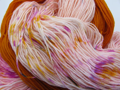 Hand-Dyed Yarn Peach Monarch A light peachy-pink skein with specks of orange, pink, and blue paired with an orange mini skein