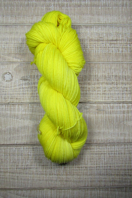 Hand-Dyed Yarn Goldie Superwash Merino/Nylon in a solid shade of golden yellow.