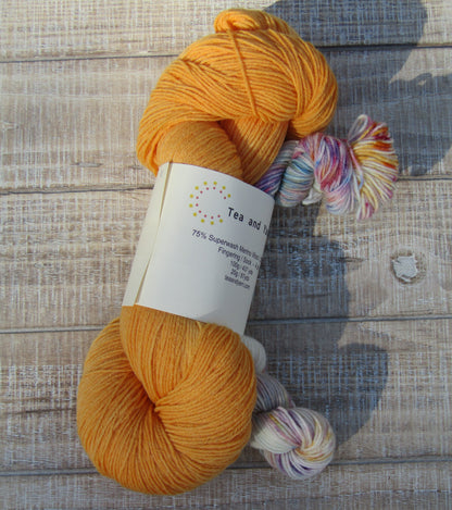 Hand-Dyed Yarn Set Light Monarch A skein of yarn in light Monarch orange with a speckled mini skein.