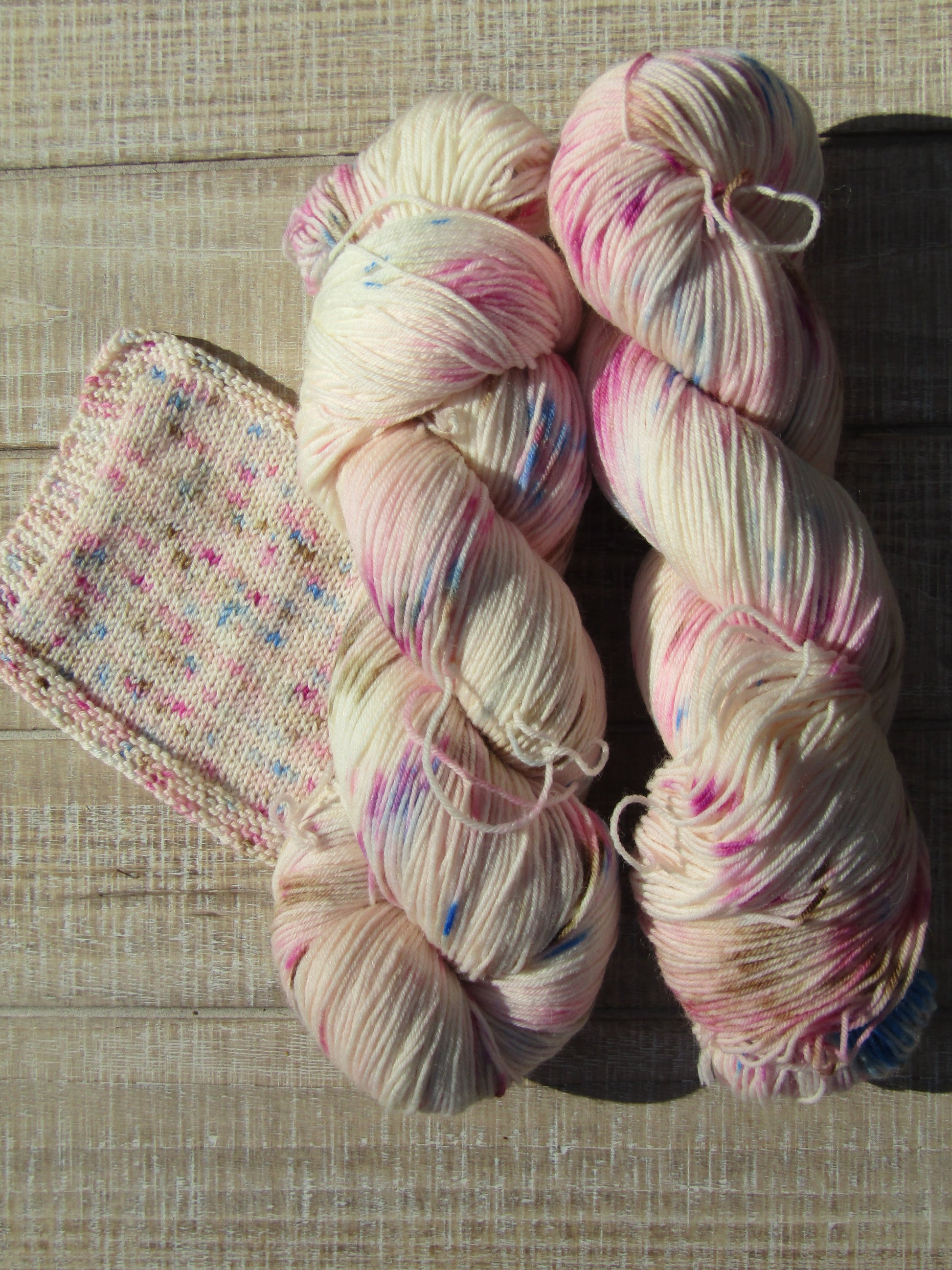 Hand-Dyed Yarn speckled with blue, chestnut, berry crush, and pink.