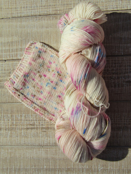 Hand-Dyed Yarn speckled with blue, chestnut, berry crush, and pink.