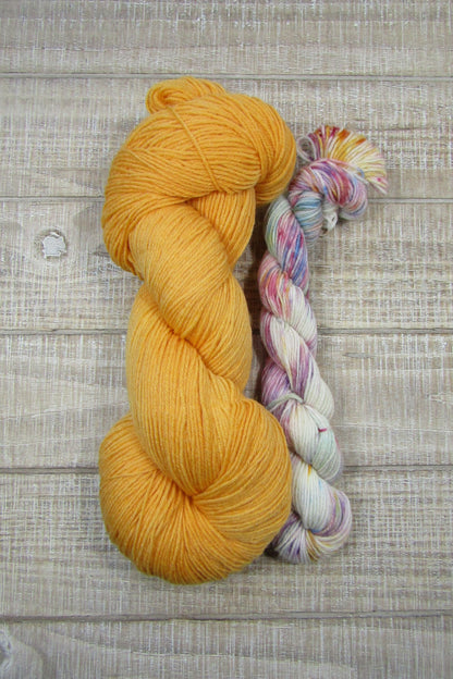 Hand-Dyed Yarn Set Light Monarch A skein of yarn in light Monarch orange with a speckled mini skein.