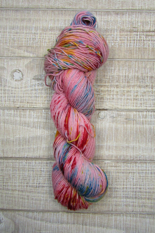 Hand-Dyed Yarn in a base color of russet with turquoise, bright yellow, green, and fire red speckles.Contents:  7
